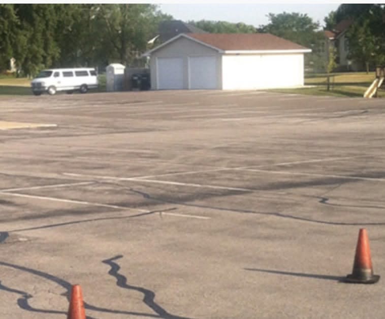 A faded, cracked parking lot with lines you can barely see