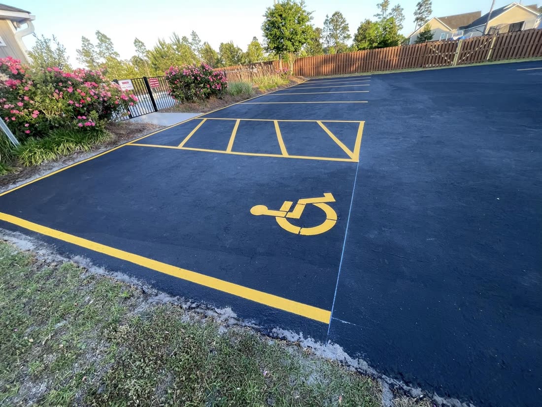 Freshly sealcoated lot with bright yellow ADA striping